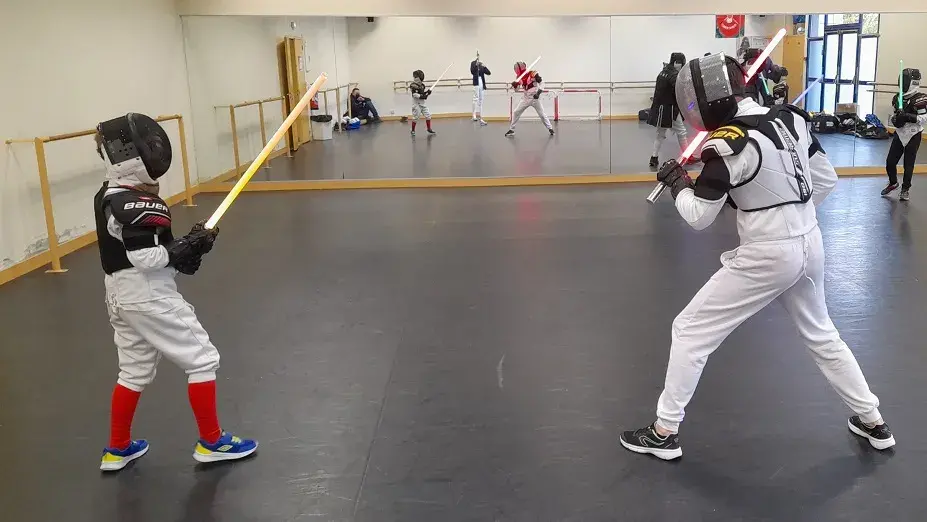 Démonstration de sabre laser devant un groupe d'enfants.
