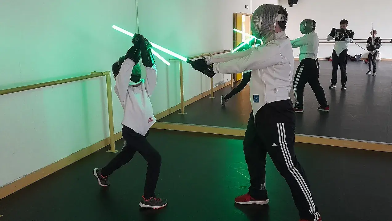 Assaut dynamique de sabre laser, lames bleue et rouge.